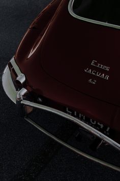 the front end of an old car with chrome trim and lettering on it's hood