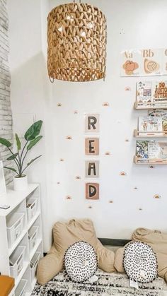 a room with some bookshelves and pictures on the wall above it, along with two pillows