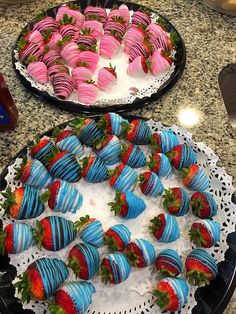 two trays filled with strawberries on top of a table