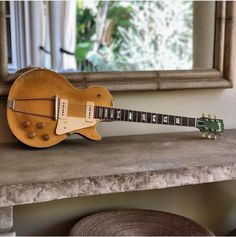 a guitar sitting on top of a table next to a mirror