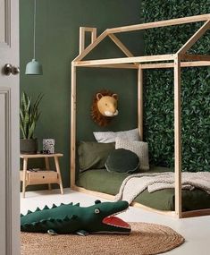 a child's bedroom with green walls and a bed made out of wooden frames