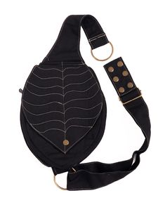 a black bag with gold dots on the side and a strap around it's waist