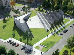 an aerial view of a building with stairs and cars parked in the parking lot next to it