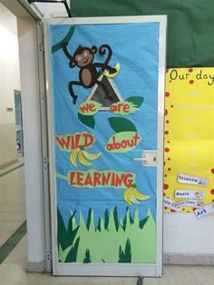 a classroom door decorated with an image of a monkey on the tree and words we are wild about learning