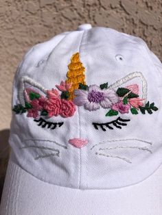 A hand embroidered adorable Caticorn adorns the front of this “dad” cap. 100% bio-washed chino twill Unstructured, six-panel, low-profile Pre-curved visor Self-fabric tri-glide buckle closure Size: 6 5/8 - 7 3/8 Cute Cotton Baseball Cap With Curved Brim, Cute Cotton Curved Brim Baseball Cap, Playful Cotton Baseball Cap For Spring, Cute Cotton Baseball Cap For Spring, Cute Spring Cotton Baseball Cap, White Cotton Hats With Custom Embroidery, White Embroidered Cotton Dad Hat, Cute Cotton Hat With Curved Bill, Cute Embroidered Adjustable Baseball Cap