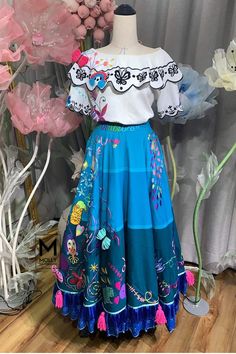 a mannequin dressed in a blue skirt and white top with flowers on it