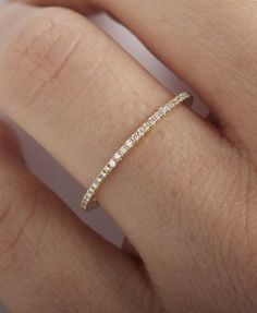 a woman's hand with a wedding band on it, and the ring is in gold