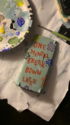 a book sitting on top of a piece of paper next to a cupcake covered in icing