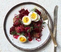 a white plate topped with meat and boiled eggs