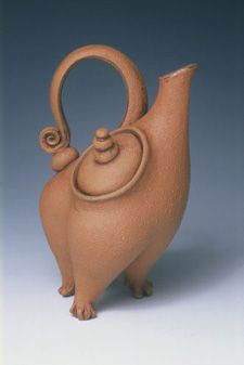 a brown ceramic teapot shaped like a bird