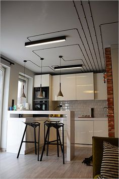 an open kitchen and living room with bar stools