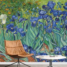 a chair sitting next to a table in front of a wall with blue flowers on it