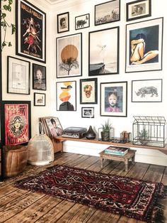 a living room filled with lots of framed pictures on the wall and wooden flooring