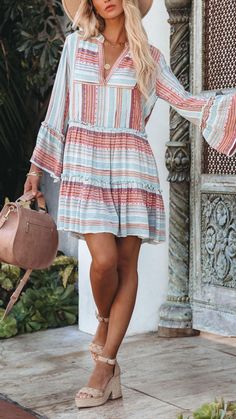 Shop around a beach town in this Dress that’s detailed with burgundy, raspberry, orange, sky blue, dusty blue, and white woven stripes. Striped Mini Dress For Beach Season, Bohemian Striped Dresses For Day Out, Striped Summer Mini Dress For Beach Season, Striped Long Sleeve Mini Dress For Beach, Striped Ruffled Mini Dress For Vacation, Bohemian Ruffled Mini Dress For Beach Season, Bohemian Mini Dress With Ruffles For Beach Season, Bohemian Striped Vacation Dresses, Bohemian Striped Dresses For Vacation