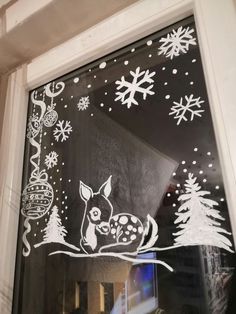 the window is decorated with snowflakes and reindeers