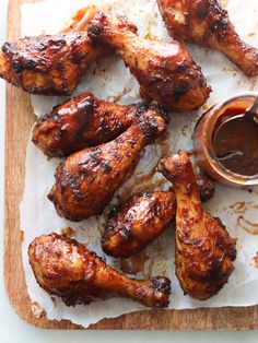 grilled chicken wings and dipping sauce on a cutting board