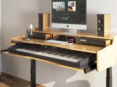 a computer monitor sitting on top of a wooden desk next to a keyboard and speakers