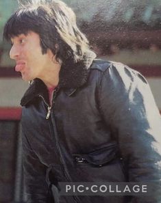 a man with long hair wearing a black jacket