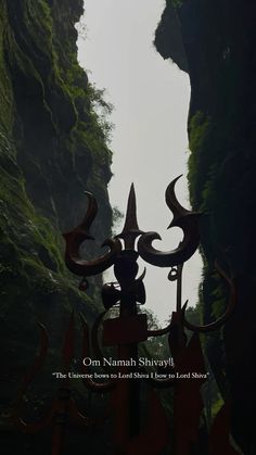 an image of a statue in the middle of a forest with mountains and trees behind it