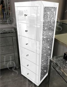 a tall white cabinet with lots of glitter on it's sides and drawers in the middle