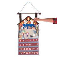 a person is holding up a christmas calendar