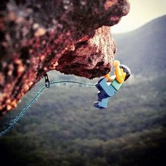 a man climbing up the side of a mountain with a rope attached to it's face