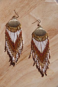 Unique pair of seedbea earrings made from Miyuki and Toho beads combined with Czech glass beads and strung with Miyuki beading thread number 5 (gold). The pair of earrings has 36 fringes and that, together with the chosen color combination, creates a chic look. The main colors are cream, cognac and gold. The ear hook is gold-colored stainless steel and hypoallergenic. The length of the earrings including ear hook is approximately 12.5 cm and the width of the ornament is 3 cm. The width of the pair is approximately 4 cm at the level of the fringes. Traditional Gold Beaded Earrings With Tassels, Traditional Gold Beaded Tassel Earrings, Traditional Gold Beaded Earrings With Tiny Beads, Traditional Gold Jewelry With Beaded Fringe, Traditional White Beaded Fringe Jewelry, Gold Tassel Dangle Earrings With Tiny Beads, Gold Tassel Earrings With Tiny Beads, Gold Tassel Earrings With Colorful Beads, White Round Beaded Tassel Jewelry