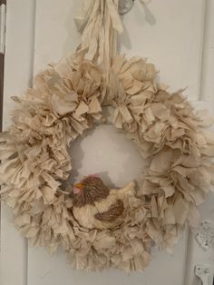 a paper wreath with a chicken on it hanging from the front door to be decorated