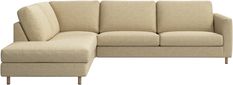 a beige couch with a footstool sitting next to it on a white background