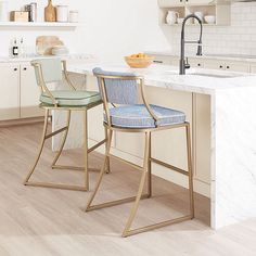 two chairs sitting on top of a kitchen counter next to an island with marble counter tops