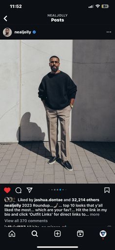 a man standing in front of a white wall with his hands on his hips and looking at the camera