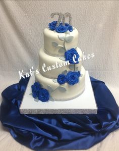 a three tiered wedding cake with blue roses