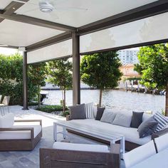 an outdoor living area with couches, tables and chairs