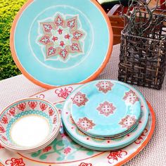 an assortment of colorful plates and bowls on a table