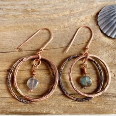 Bronze hoops with Labradorite drop earrings, Double large ring hoops get soft sparkle from Labradorite. These rustic rings are made bronze, other metal parts are copper. Labradorite dangles added for great movement. See the sparkle inside the perfect rustic circle! The traditional 19-year anniversary gift is made of bronze, a strong and durable material that symbolizes a rock solid marriage.  The hoops are handcrafted so there is slight variation on the size. The larger hoop has been patinated slightly darker. (If you want it regular bronze tone I can sand the patina off.) Copper hook earwires. (If you prefer Sterling silver earwires plese message).  Bronze is a copper metal consisting of mostly copper and a small amount of tin. * * * * * * * * * * * * * * * * * * * * * * * * * * * * * * * Bohemian Copper Hoop Jewelry, Bronze Copper Hoop Earrings, Artisan Bronze Hoop Earrings With Ear Wire, Brown Copper Bohemian Hoop Earrings, Artisan Copper Hoop Earrings, Pierced, Rustic Rings, Year Anniversary Gifts, Boho Earrings, Labradorite