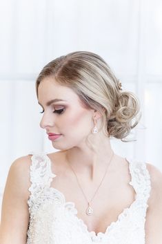 a woman wearing a wedding dress and earrings