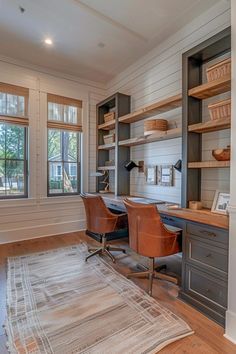 a home office with built in shelving and wooden floors, along with a rug on the floor