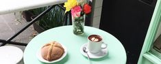 a table with two plates of food and a cup of coffee sitting on top of it