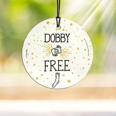 a white ornament with the words dobby is free hanging from a string