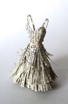 an origami dress made out of newspaper strips and paper machs with words written on it