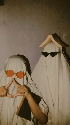 two mannequins dressed in white and black with orange glasses on their faces