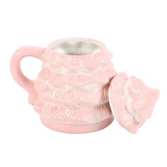 a pink ceramic teapot with two cups on it's sides and the lid open