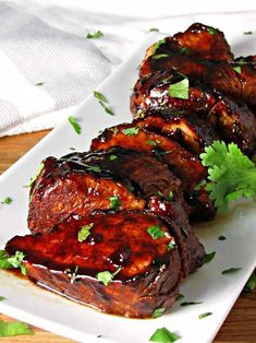 grilled pork chops with cilantro on a white platter, ready to be eaten