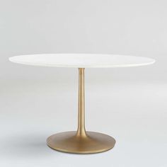 a white table with a gold pedestal base