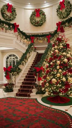 a christmas tree in the middle of a room with stairs and wreaths on it