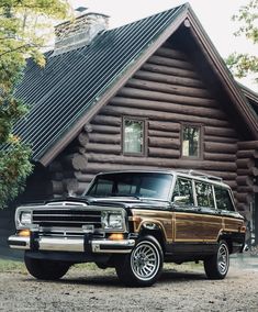 an suv parked in front of a log cabin