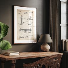 a table with a lamp and some books on it in front of a wall mounted poster