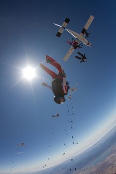 several people are flying kites in the sky with one person upside down on it