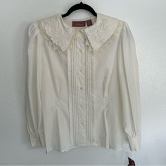 Open To Reasonable Offers!!! -Lace And Embroidery Detailing -Button Up -Fit And Flare -Shoulder Pads Size: 12 Color: White/ Cream Condition: New With Tags (Small Stain In Last Photo) Smoke And Pet Free Home Measurements Upon Request Classic Cream Blouse With Buttons, Classic Collared Tops With Lace Trim, Classic Blouse With Buttons For Vintage Fashion, Retro Formal Blouse With Buttons, Vintage White Blouse For Formal Occasions, White Retro Formal Tops, White Retro Blouse For Formal Events, White Retro Blouse For Formal Occasions, Classic Cream Blouse With Lace Collar