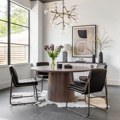 a dining room table with two chairs and a chandelier hanging from the ceiling